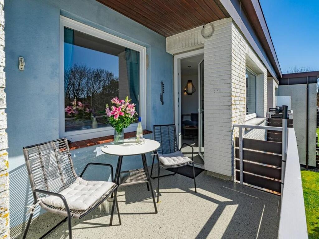 a patio with a table and chairs and a balcony at One-bedroom apartment in Westerland (Sylt)