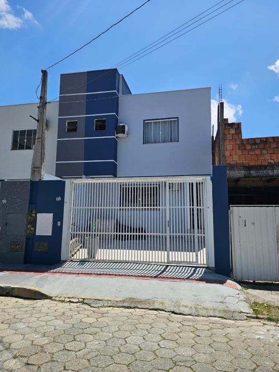 ein blau-weißes Gebäude mit einem Tor in der Unterkunft Aproveite suas férias em família in Balneário Camboriú