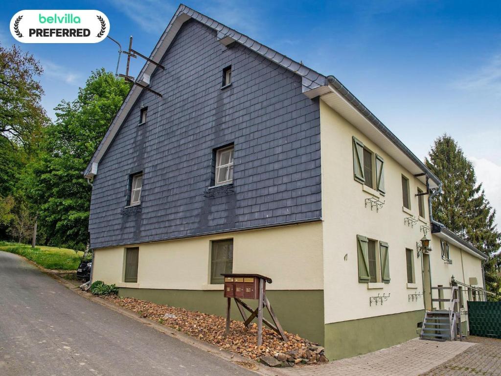 a house with a black roof on a street at Holiday Home near Ravel Cycling paths in Heuem