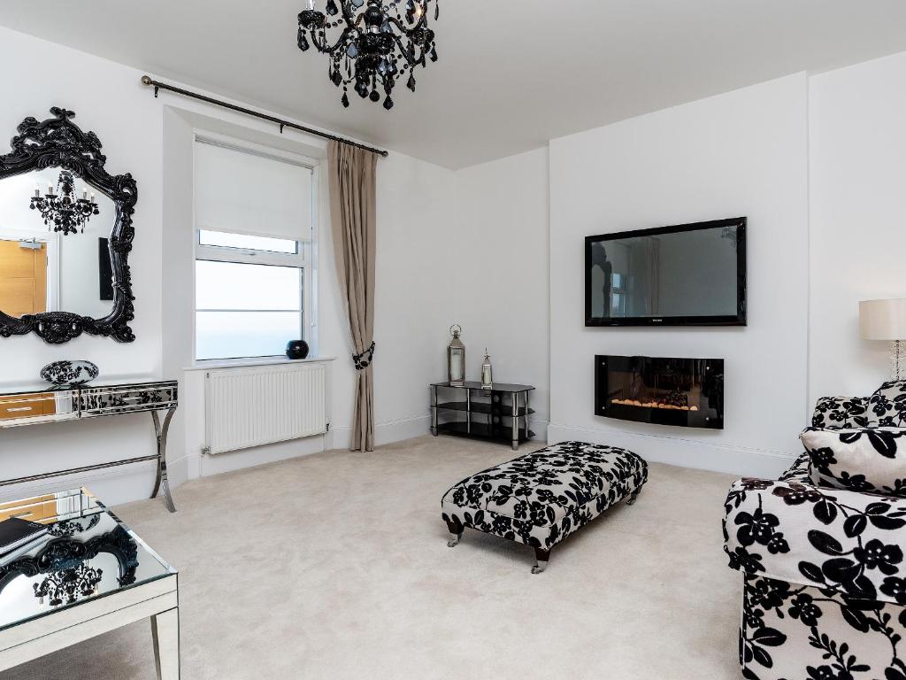 a living room with a chair and a tv at Babbacombe Bay, Torquay in Torquay