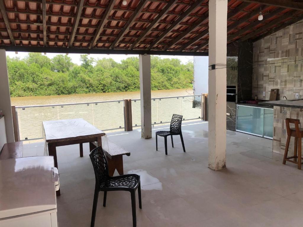 eine Terrasse mit Tisch und Stühlen und eine Küche in der Unterkunft Casa beira rio em Prado in Prado