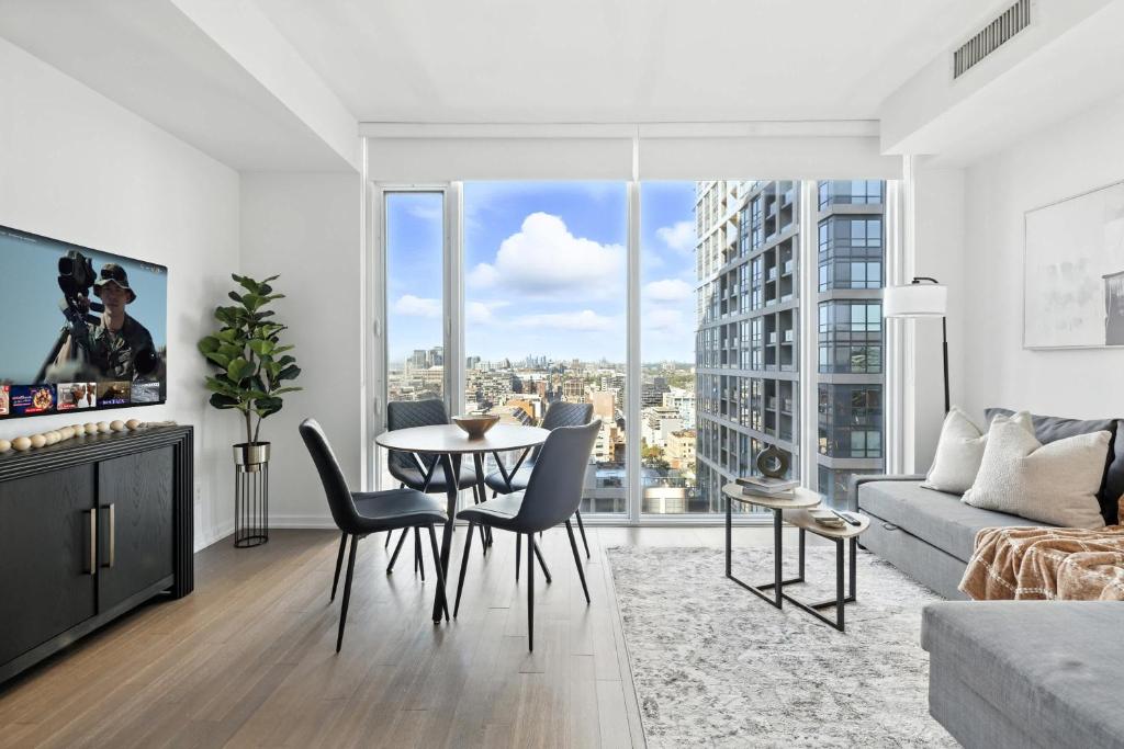 a living room with a table and a large window at Stylish 1BR Condo in the heart of the Downtown TO in Toronto