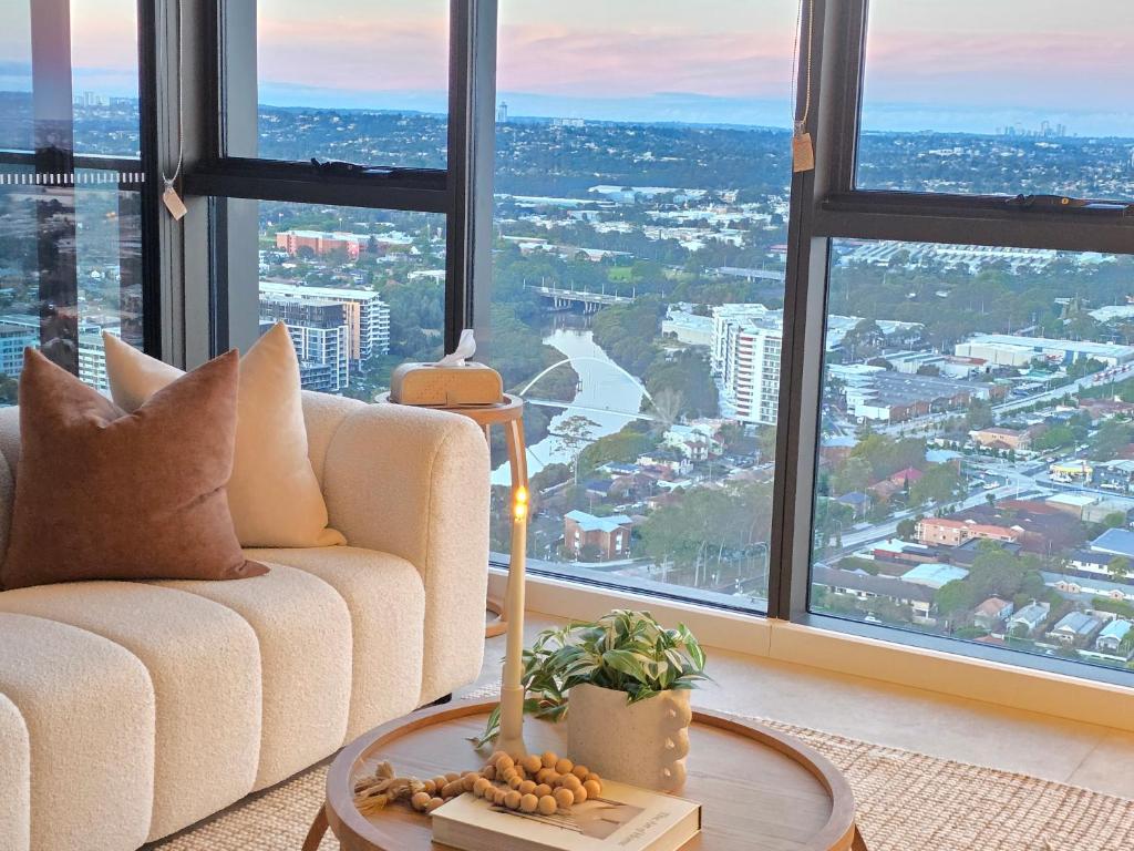 a living room with a couch and a large window at Paramount Suite on Parkes Pool And City View in Sydney