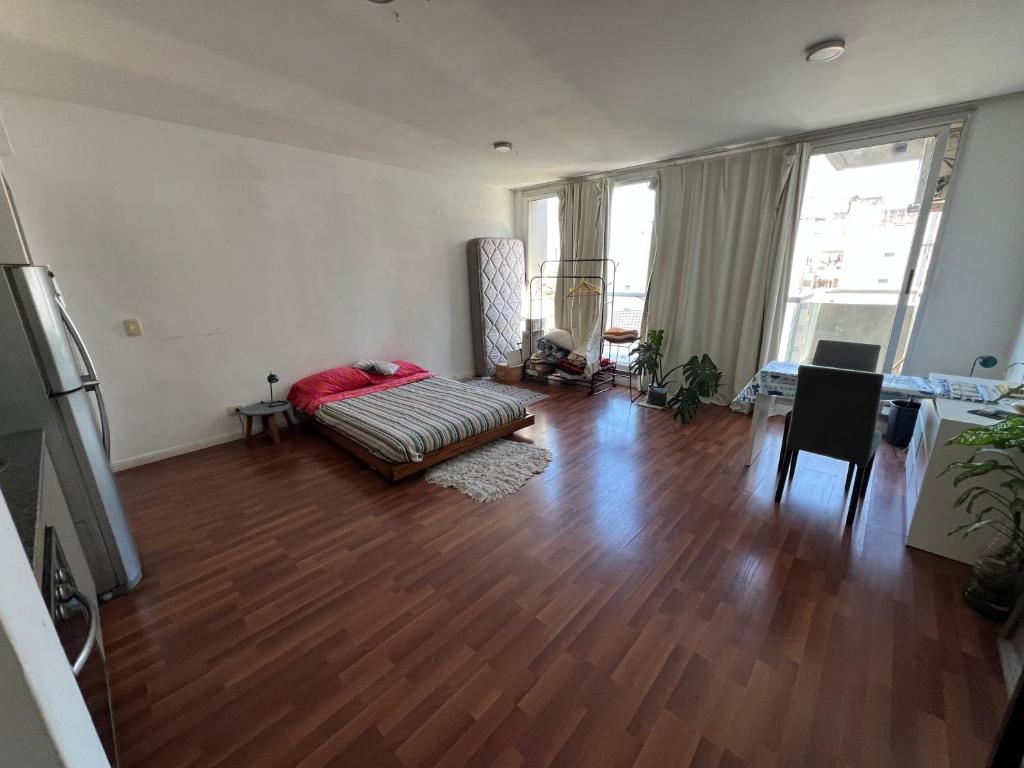 Una sala de estar con un sofá y suelo de madera. en Depto en Buenos aires, en Buenos Aires