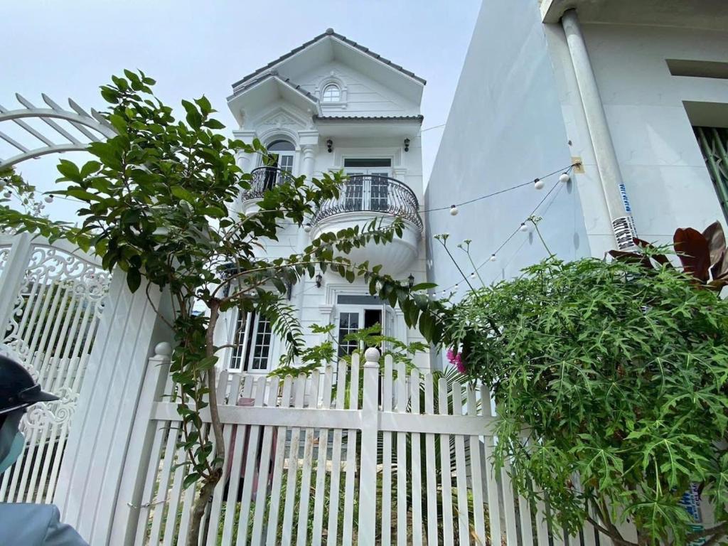 a white fence in front of a white house at Nhà nguyên căn 3 phòng ngủ in Ấp Bình Hưng