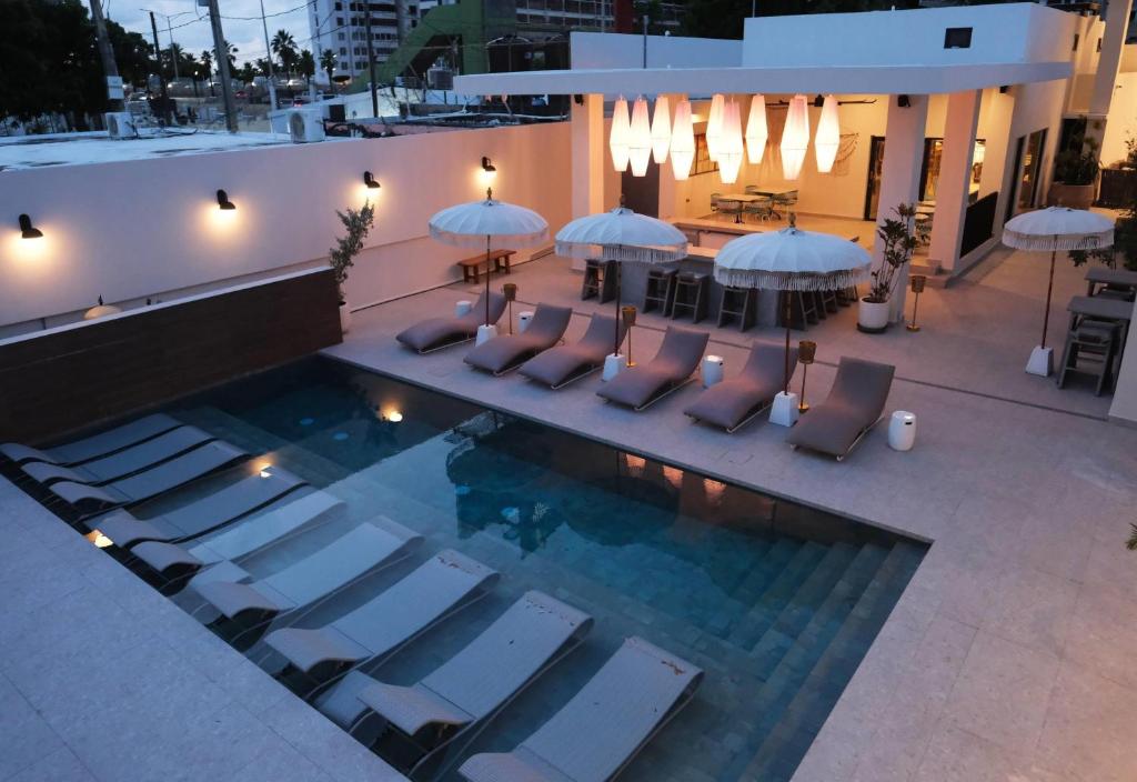 Una vista aérea de una piscina con tumbonas y sombrillas. en Bali Hotel Adults Only Isla Verde, a Trademark by Wyndham, en Carolina