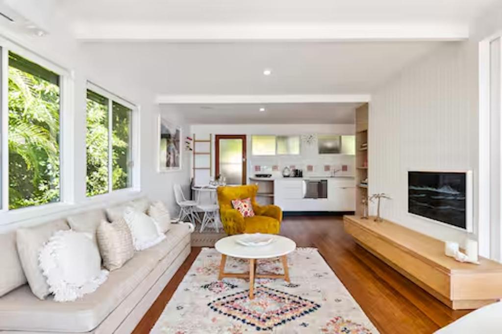 a living room with a white couch and a table at Seaviews Little Cove Beach Noosa 2BR 200m to beach in Noosa Heads