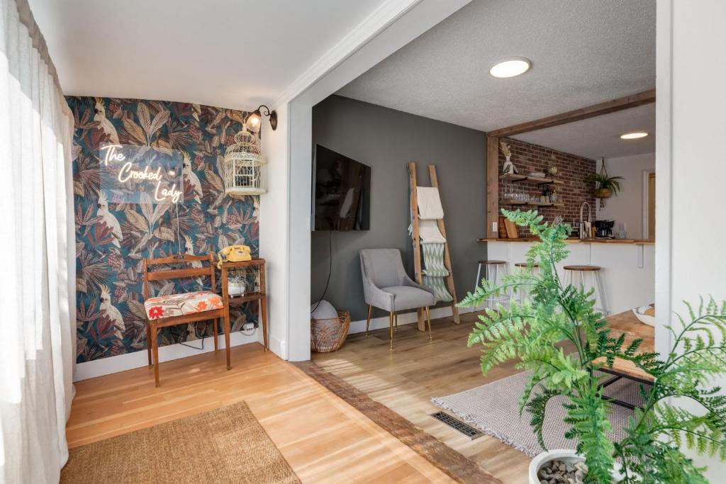 ein Wohnzimmer mit einem Tisch und einem Stuhl in der Unterkunft The Crooked Lady Cozy Bungalow near Downtown Calgary with Free Parking in Calgary