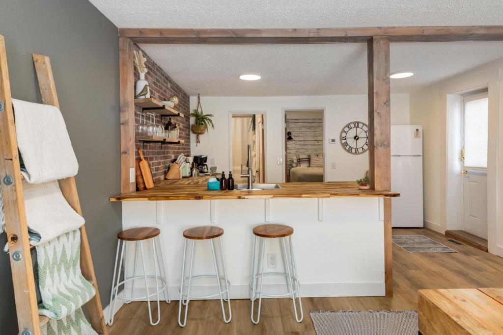 eine Küche mit einer Theke und Hockern in einem Zimmer in der Unterkunft The Crooked Lady Cozy Bungalow near Downtown Calgary with Free Parking in Calgary