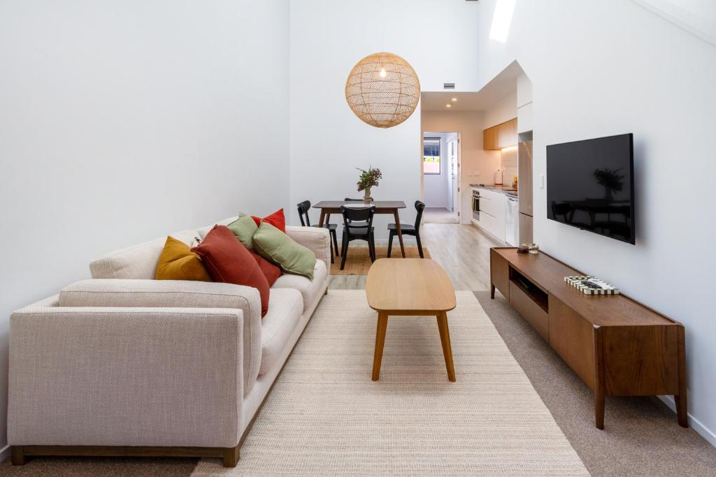 a living room with a couch and a table at Central Christchurch Apartment with Parking in Christchurch