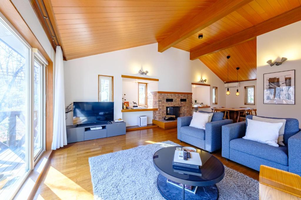 a living room with a blue couch and a table at Villa Lina in Naganohara