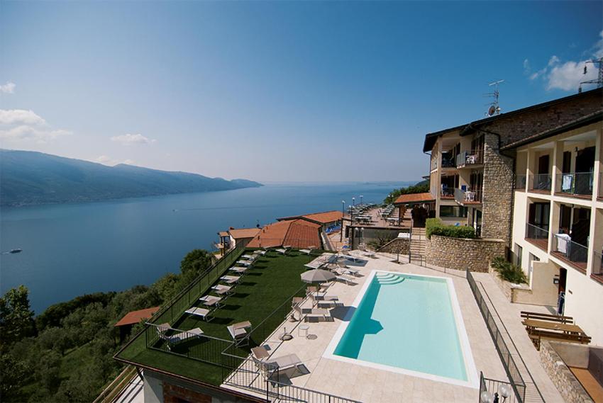 una piscina en un edificio con vistas al lago en Residence Ruculì - Ruculì Hospitality, en Tignale