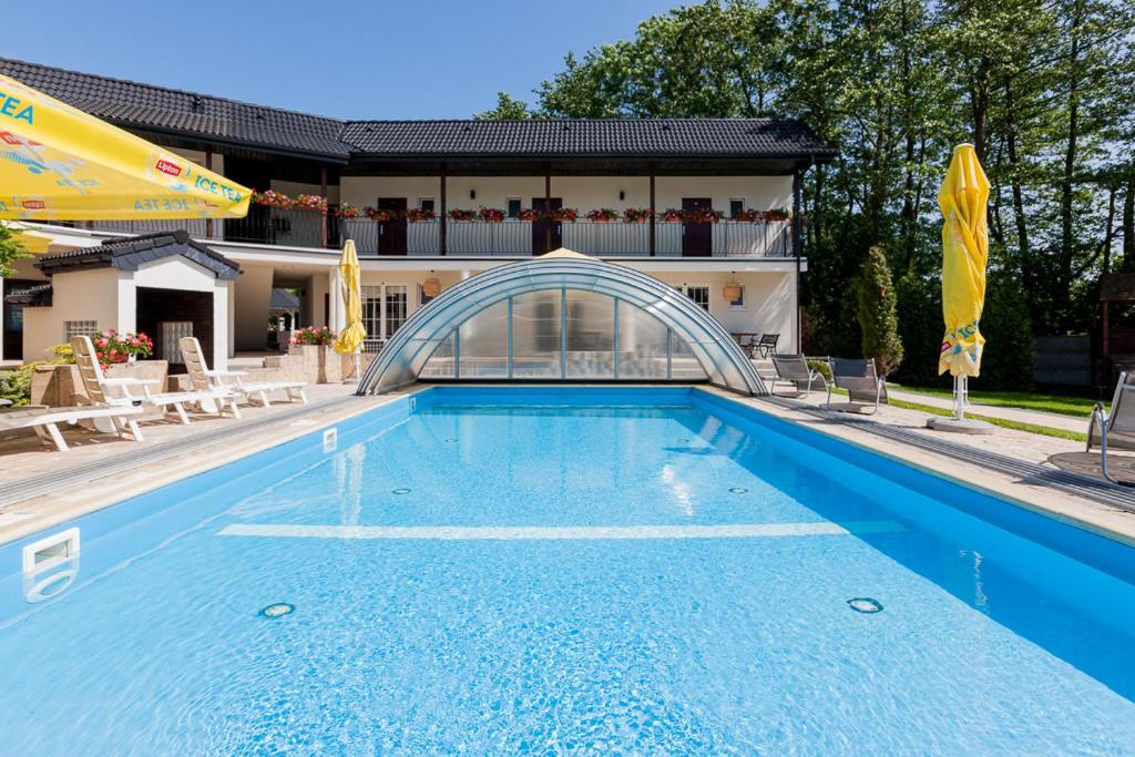 a large blue swimming pool with a building in the background at Perła Bałtyku in Pustkowo