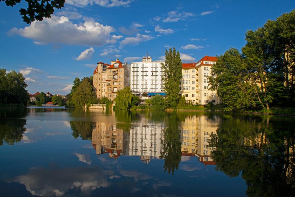 un reflejo de un edificio en el agua en Ringhotel Seehof, en Berlín