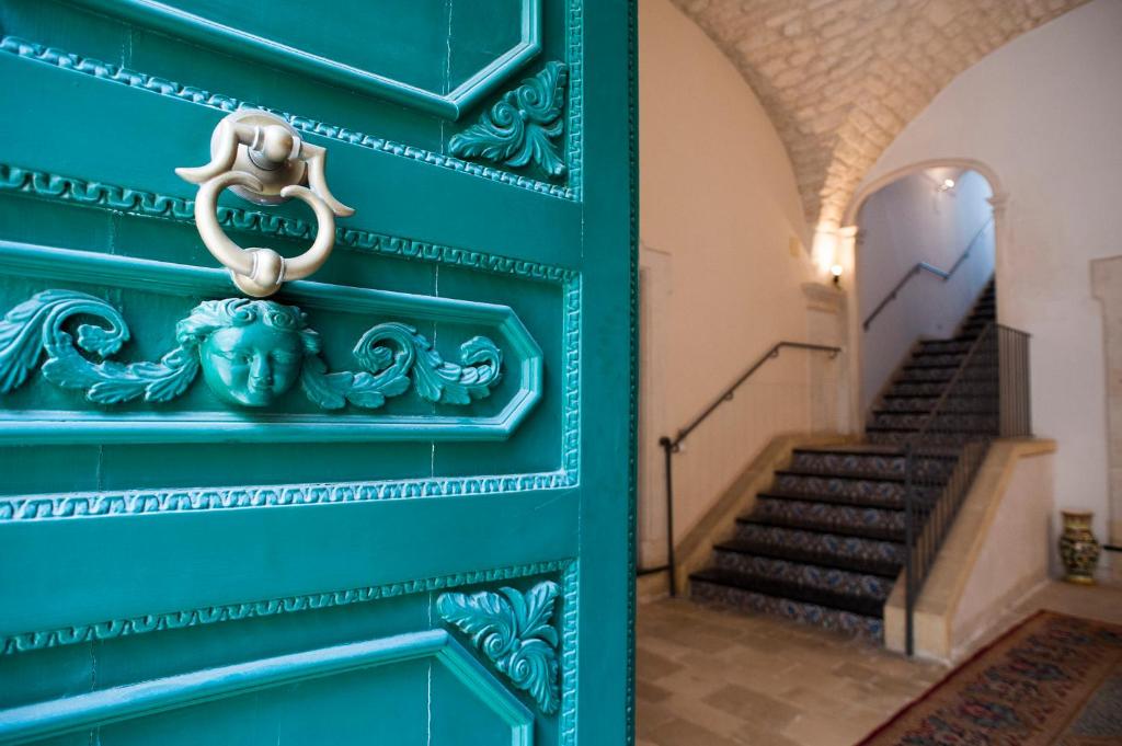 a blue door in a building with stairs at Palazzo Conti Camere & Suites in Scicli