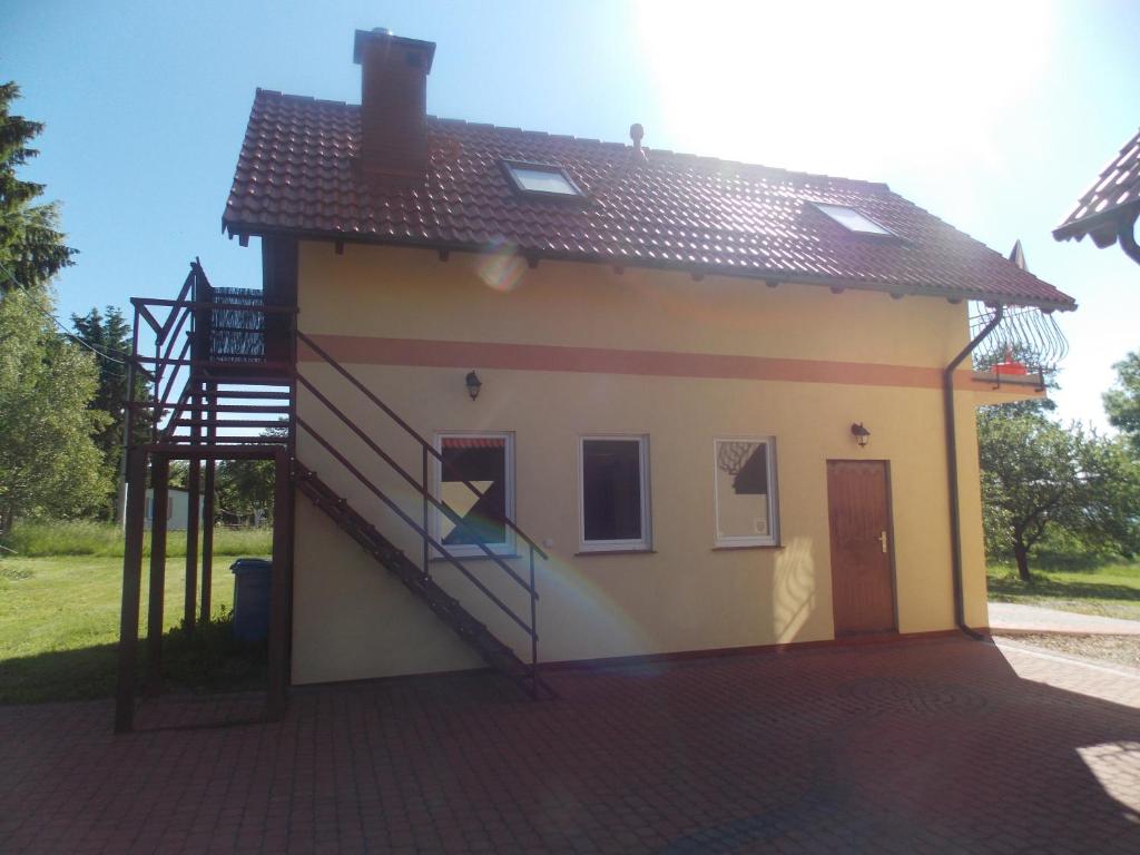uma pequena casa com uma escada ao lado em Mazury Home em Giżycko