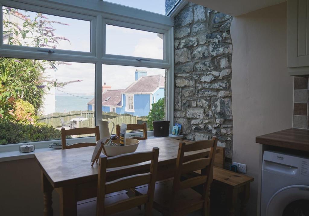 une salle à manger avec une table et une grande fenêtre dans l'établissement 3 Prospect Place, New Quay, sleeps 6, parking, sea views, dog friendly, à New Quay