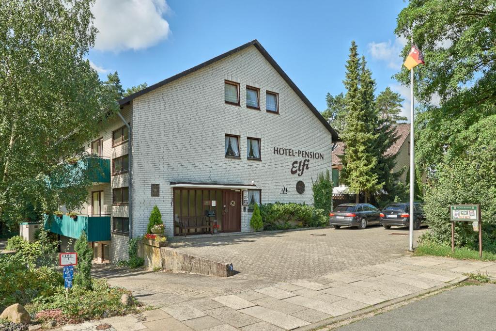 a building with a parking lot in front of it at Hotel-Pension Elfi in Bad Bevensen