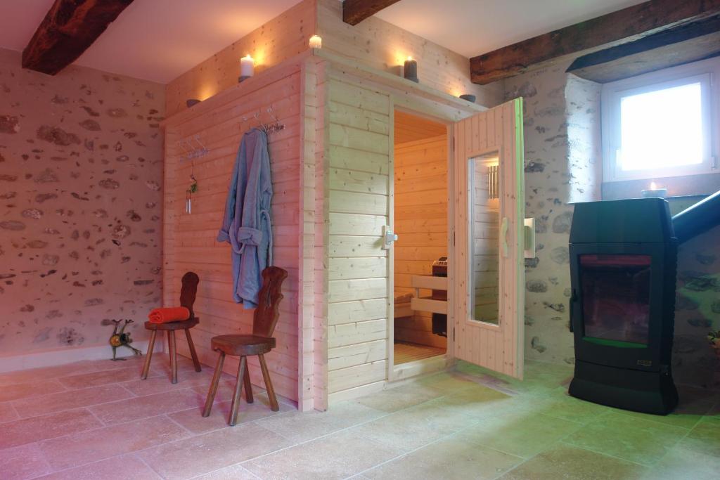 a room with a room with a fireplace and chairs at La Bigourd'in in Escoubès-Pouts