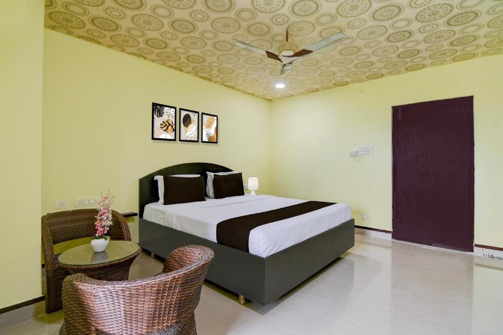 Super Collection O Rama Lakshmana Junction Srikakulam في Srīkākulam: غرفة نوم بسرير وكرسيين وسقف