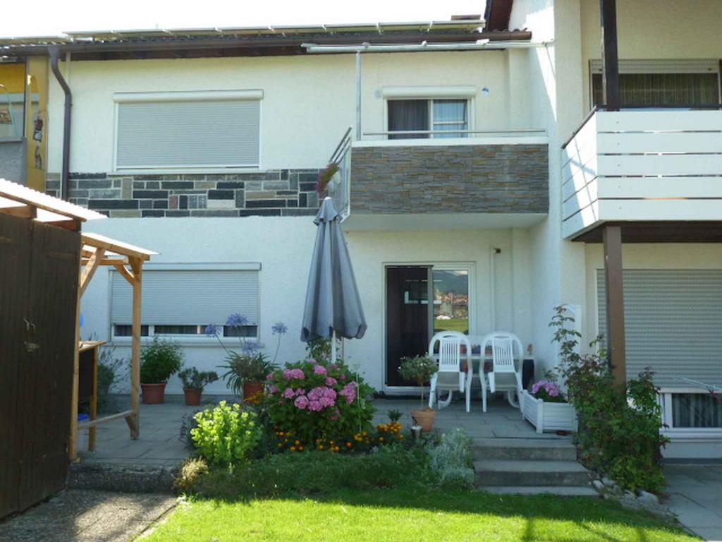 a patio with an umbrella and a table and chairs at Privatzimmer Reiner Baumeister in Lindau