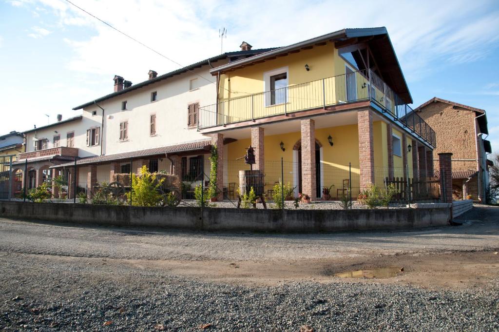 uma grande casa amarela ao lado de uma rua em Agriturismo Il Vecchio Portico em Francavilla Bisio
