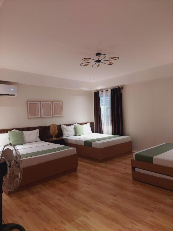 ein Schlafzimmer mit zwei Betten und einem Deckenventilator in der Unterkunft The Grove by Six Marys Resort in Bacolor