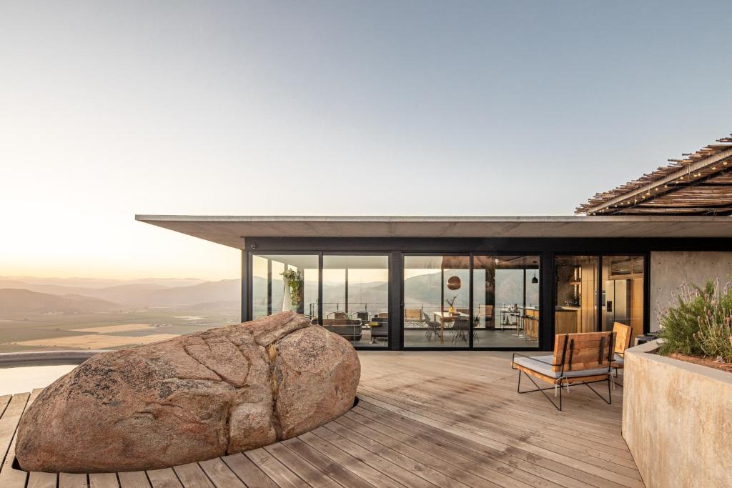 un gros rocher se trouve sur la terrasse d'une maison dans l'établissement Casa Gracia Valle de Guadalupe, à El Sauzal