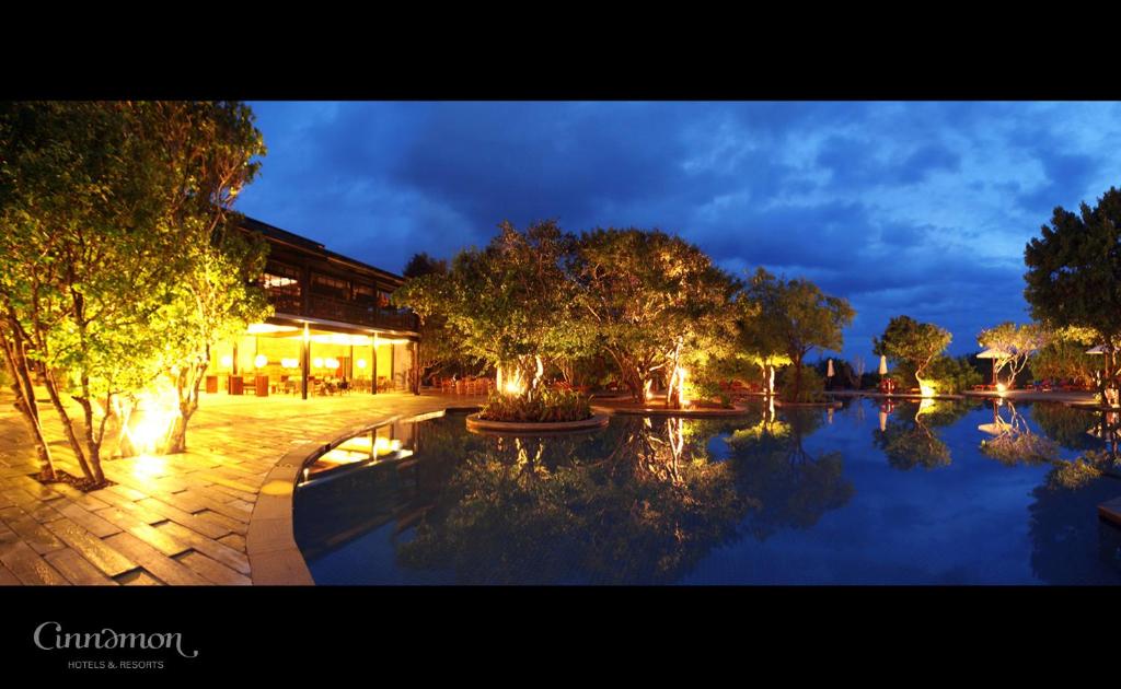 a large pool of water with trees and a building at Cinnamon Wild Yala in Yala