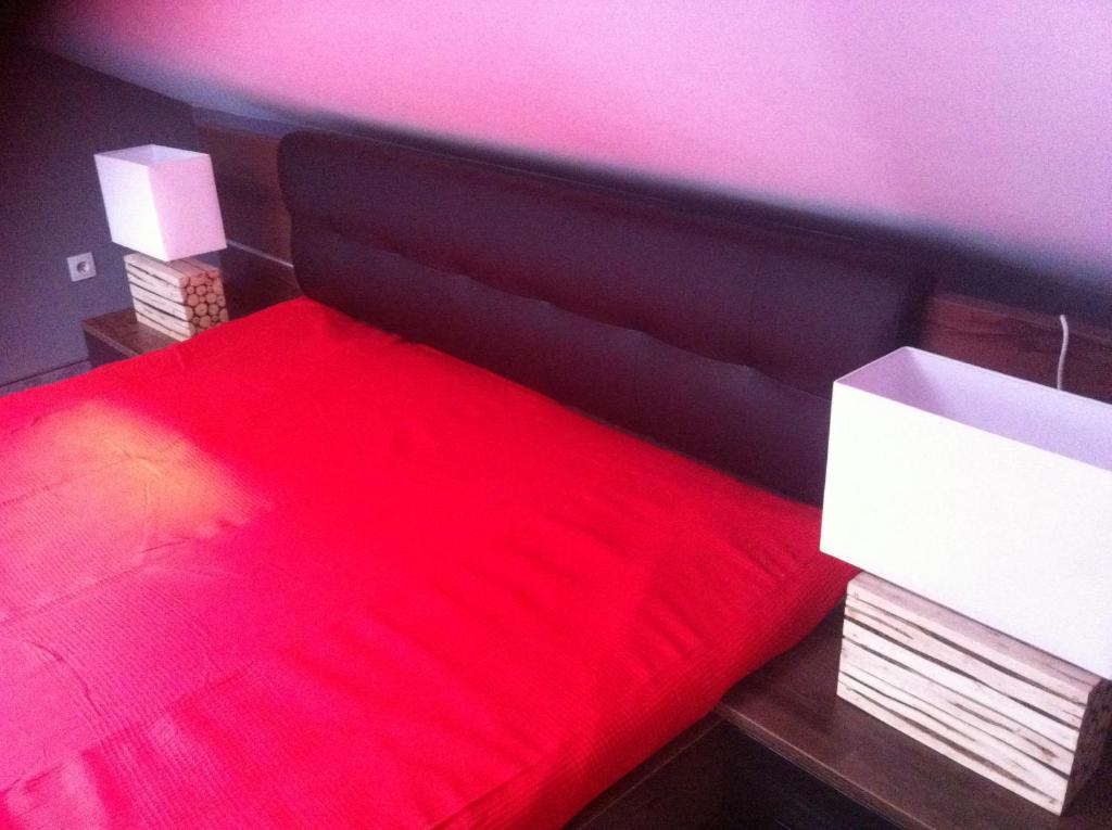 sypialnia z czerwonym łóżkiem z czarnym zagłówkiem w obiekcie Mieszkanie w Centrum Olesna w mieście Olesno