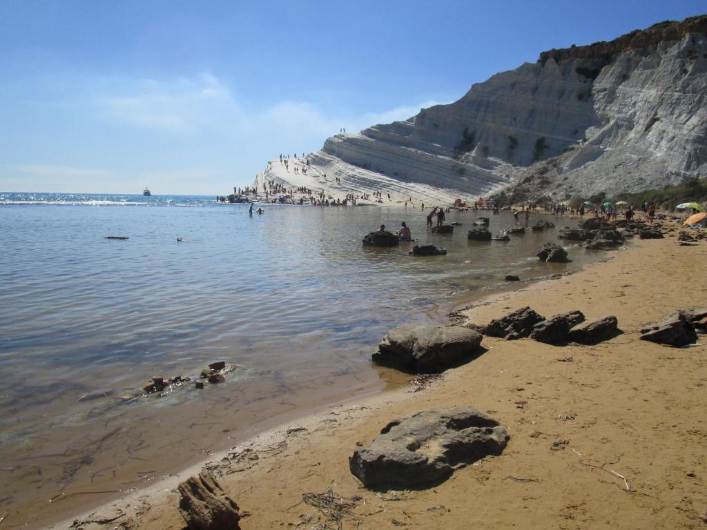 un grupo de personas en una playa cerca del agua en Playa Dei Turchi, en Realmonte