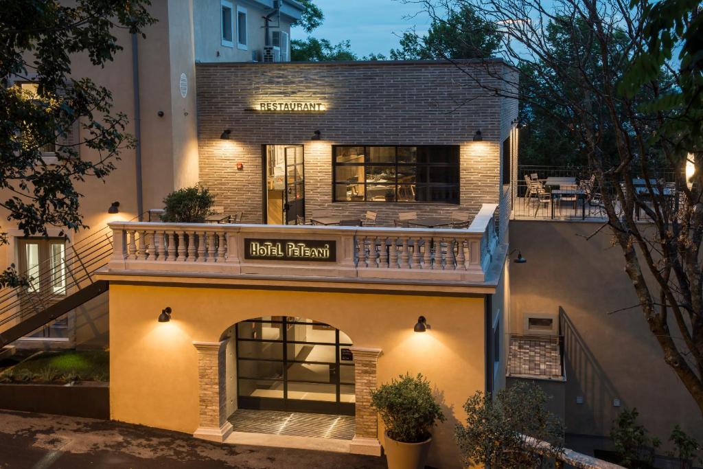 a building with a balcony on top of it at Hotel Peteani in Labin