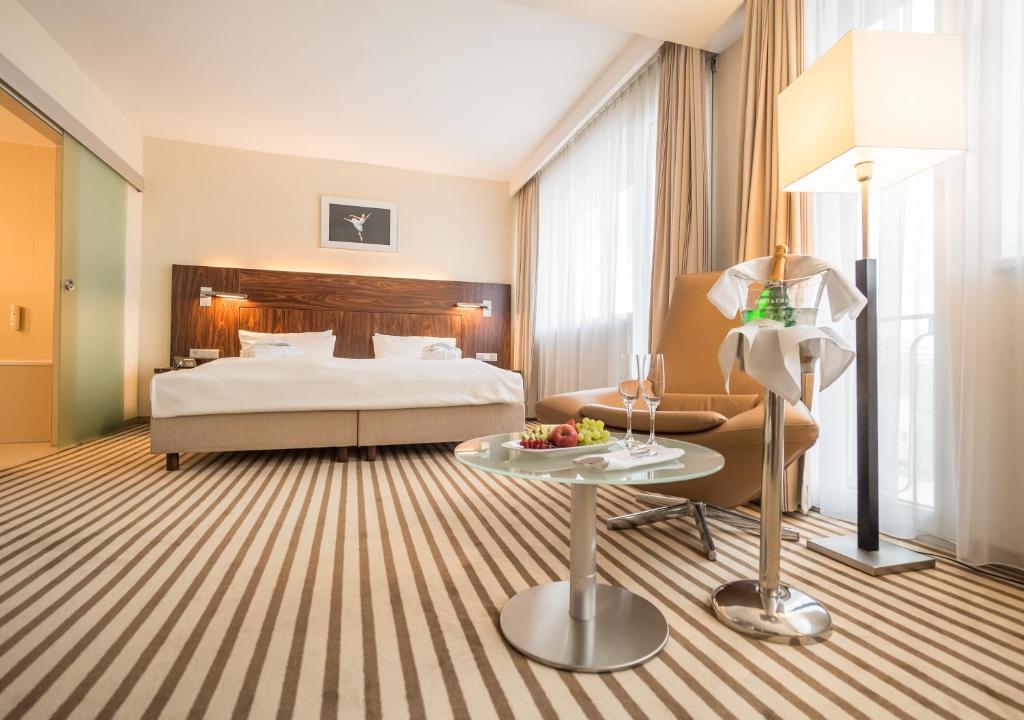 ケムニッツにあるホテル アン デア オーパのベッドとテーブルが備わるホテルルームです。