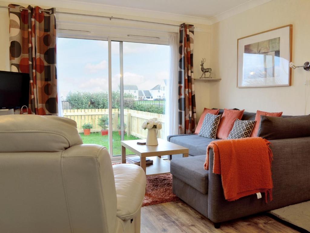 a living room with two couches and a large window at Harbour View in Tayport