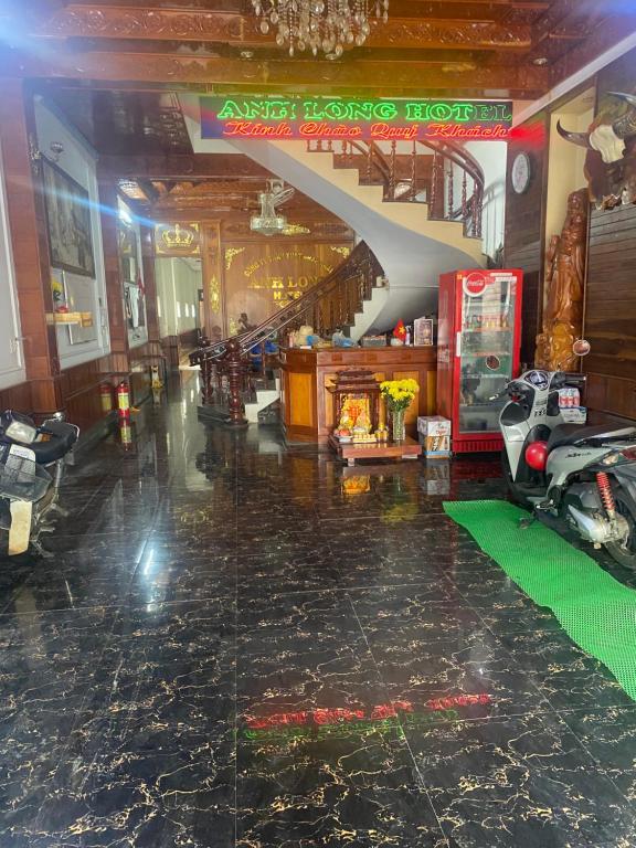 a lobby with a staircase and a motorcycle on the floor at Hottel ANH LONG in Buôn Ðũng