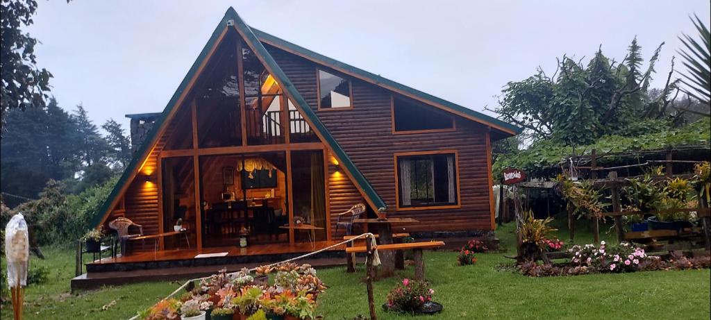 a small wooden house with a large window at Magic Cabin in Jardín de Dota A real Costa Rican Farm experience with Breakfast included Trout fishing in the lagoon Fruit tasting & beautiful garden with farm animals in Santa María