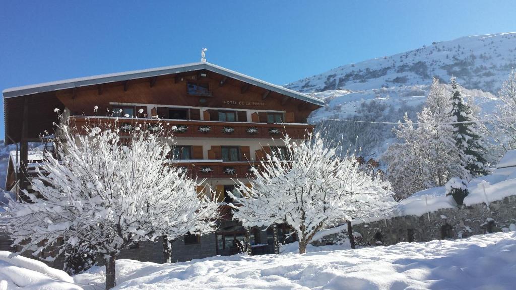 a building with snow covered trees in front of it at Hôtel de la Poste in Valloire
