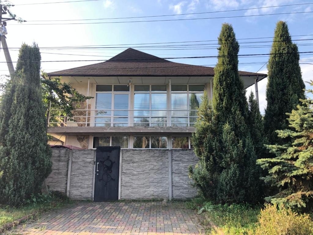 a house with a gate and two trees at Тownhouse99 in Petropavlovskaya Borshchagovka