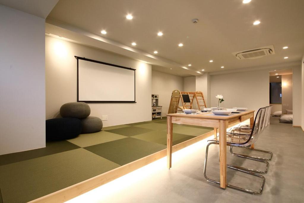 a dining room with a table and chairs in a room at BROOMSTAY Umeda west in Osaka