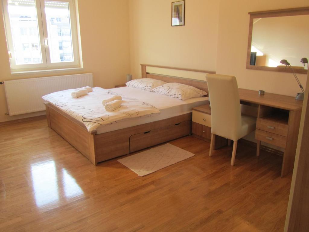 Schlafzimmer mit einem Bett, einem Schreibtisch und einem Spiegel in der Unterkunft Apartment Domi Kvatric in Zagreb