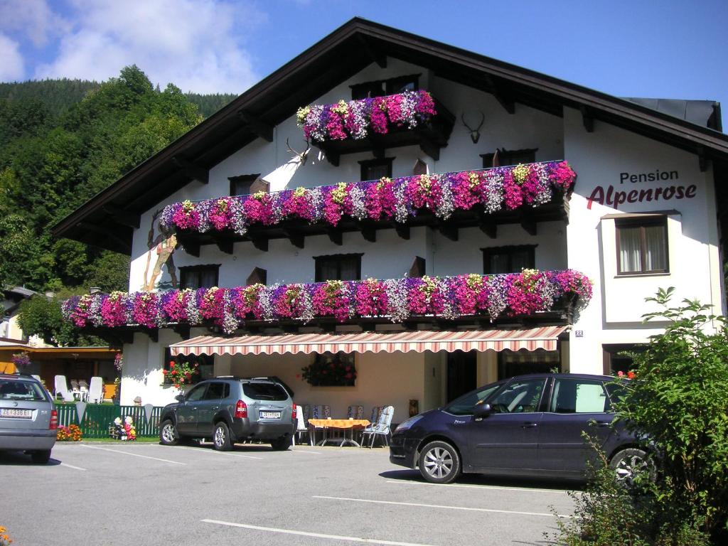 un bâtiment avec des boîtes de fleurs sur son côté dans l'établissement Pension Alpenrose, à Zell am See