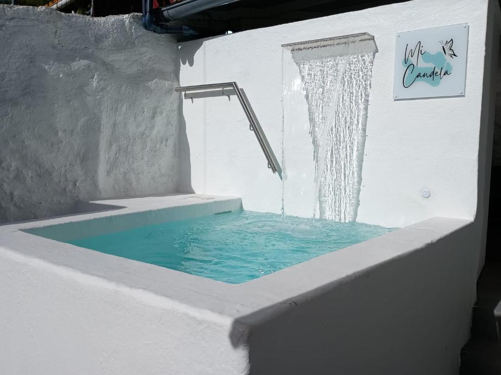 eine Badewanne mit einer Dusche mit blauem Wasser in der Unterkunft Mi Candela in Valleseco