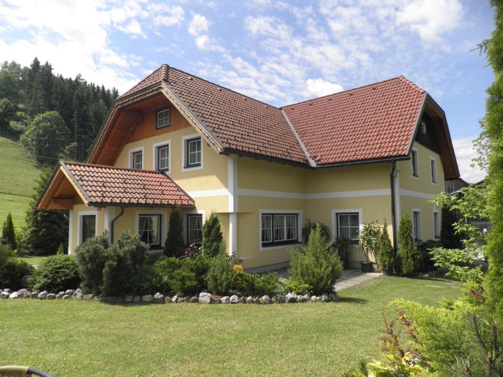 ein Haus mit einem gefliesten Dach in der Unterkunft Bio-Landhaus Kesslerhof in Gröbming