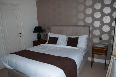 a bedroom with a large bed with white sheets and pillows at The Hare and Hounds in Fulbeck