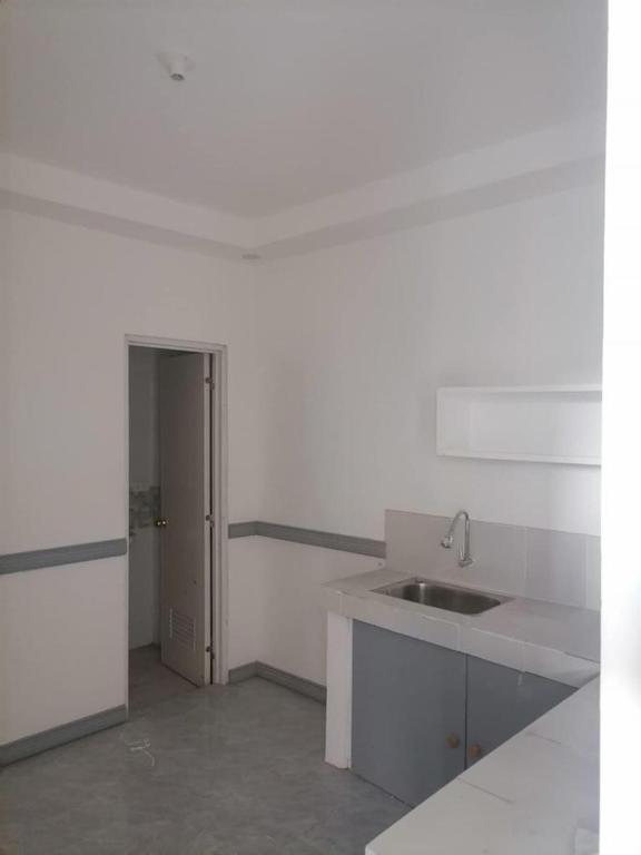 a white kitchen with a sink and a counter at Alexander Dones Apartment in Sangley Point Naval Station