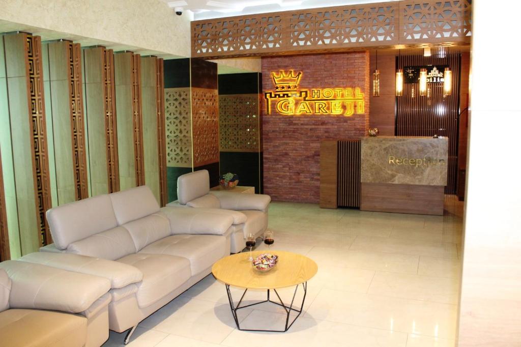 a lobby with couches and a table and a sign at Hotel Panorama Gareji in Sagarejo