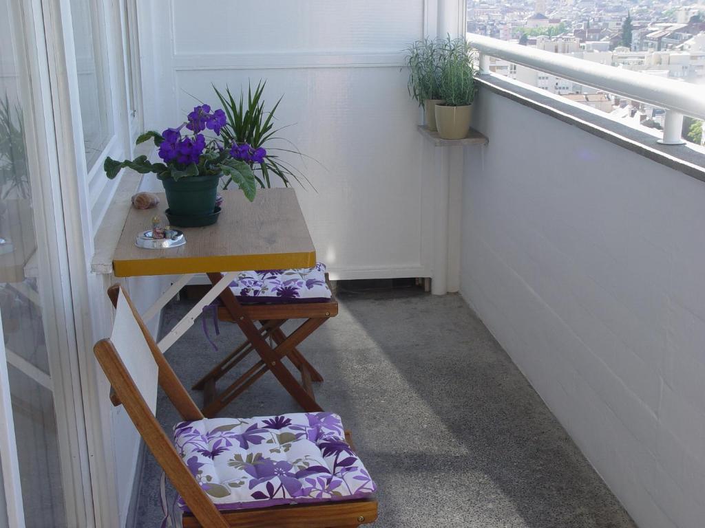 a balcony with a table and a chair and flowers at Apartment Maka in Split