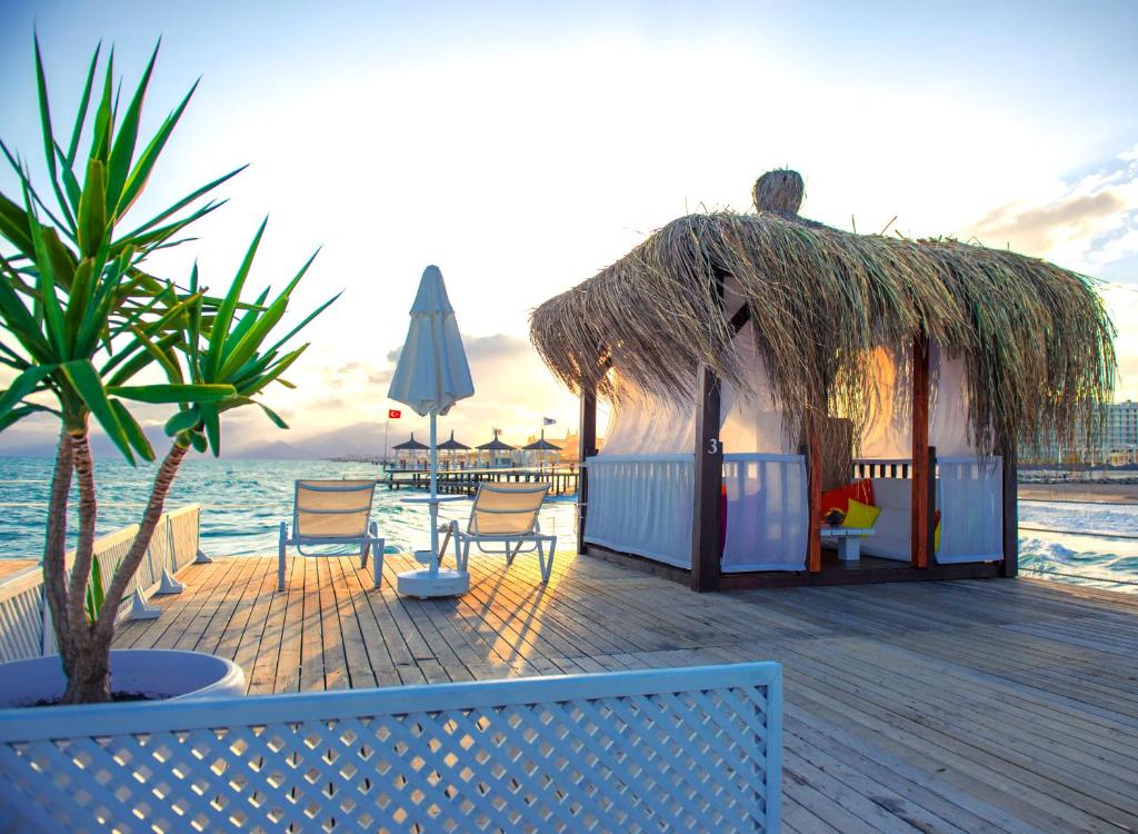 a gazebo with chairs and a umbrella on the beach at Liberty Hotels Lara in Lara