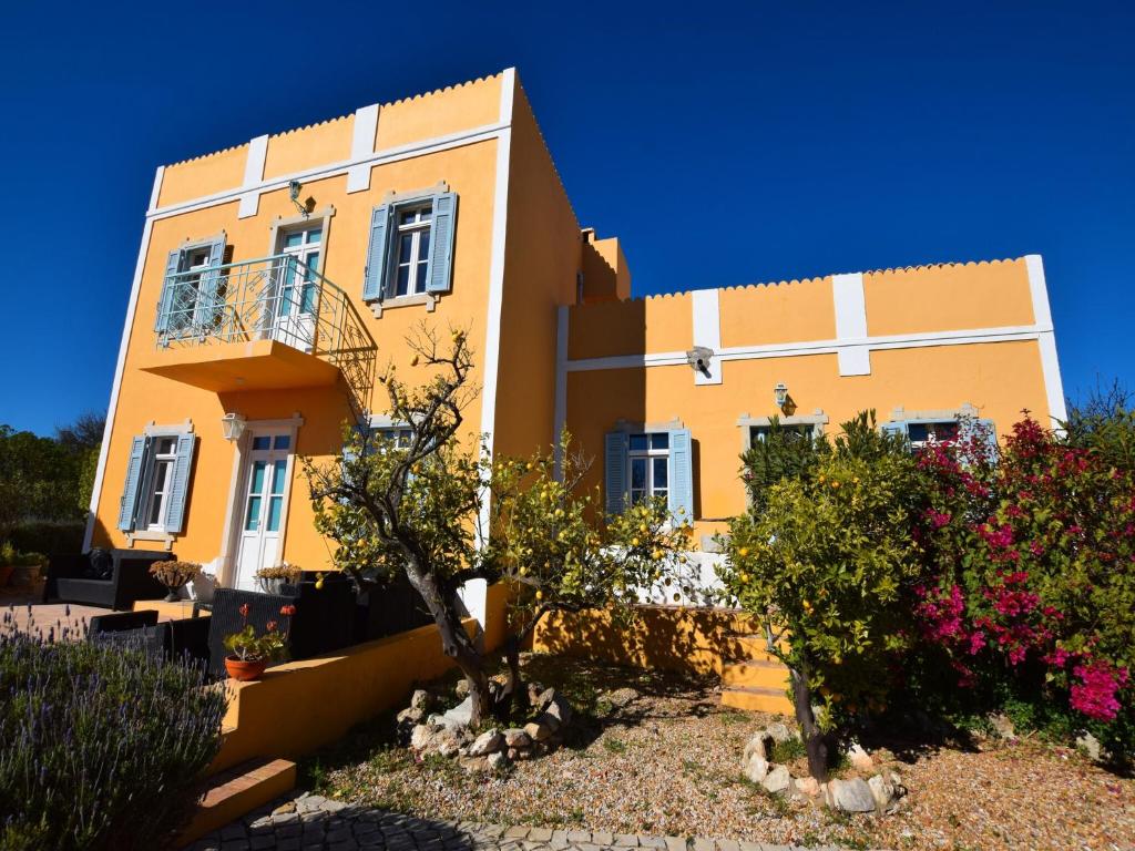 a yellow house with a tree in front of it at Delightful, authentic Quinta with pool in Loulé