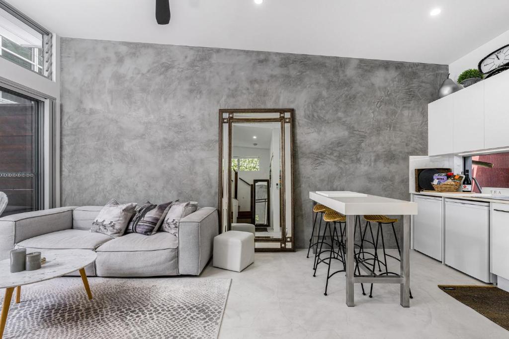 una sala de estar con un sofá y una mesa en Studio 9 - Luxury Apartment, en Byron Bay